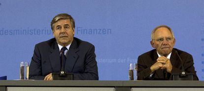 El ministro Schäuble (derecha) junto al banquero Ackermann presentan la decisión ayer en Berlín.