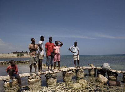 Un grupo de haitianos observa el cadáver de una de las víctimas del naufragio.