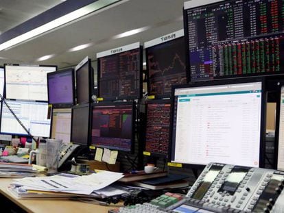 Un corredor de bolsa trabaja frente a monitores en la Bolsa de Seúl (Corea del Sur).