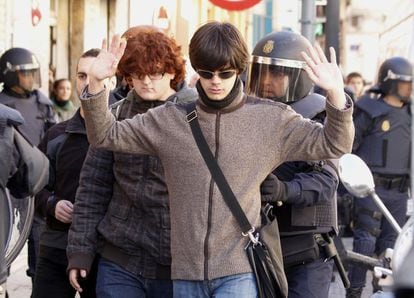 Un policía registra a un joven durante la concentración en Valencia.