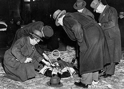 La policía examina el cadáver de Louis Cohen, asesino de Kid Dropper. Fotografía del <i>Daily News</i> de Nueva York, publicada en 1939, en la exposición del Museo Judío de Viena.