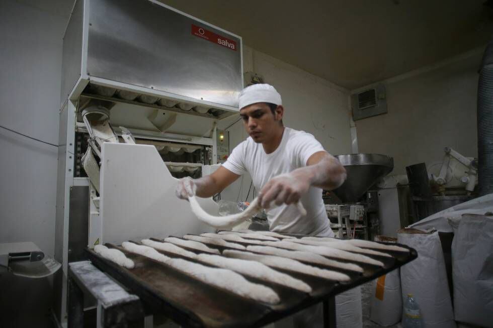 Un trabajador prepara hogazas de pan en una panadería de Lugo.