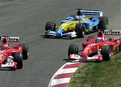 Fernando Alonso toma una curva en presencia de los dos ferraris.