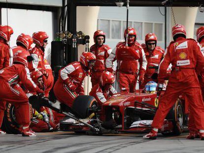 Fernando Alonso, con sus mecánicos en boxes.