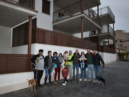 Algunos de los nuevos vecinos de Letur (Albacete) junto a los pisos donde viven.