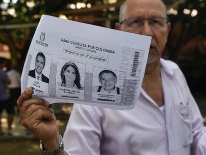 Un hombre muestra una fotocopia de la consulta de la derecha colombiana para elegir su candidato presidencial.