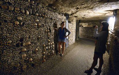 Dos turistas en las catacumbas de París, en las que hay más de seis millones de huesos.