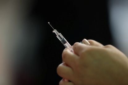 Una enfermera prepara una vacuna para la campaña estacional contra la gripe.