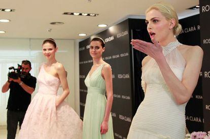 El modelo andrógino Andrej Pejic (derecha) posa vestido de novia junto a otras dos modelos en la Barcelona Bridal Week.