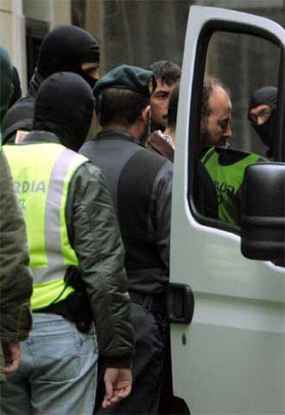La Guardia Civil introduce en un furgón a dos detenidos en Alicante.