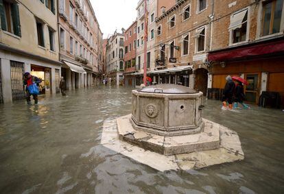Algunas personas caminan por la inundada plaza de Campo Santi Filippo e Giacomo de Venecia, este viernes.