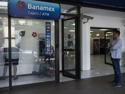 Un cliente hace fila para usar un cajero automático en una sucursal bancaria de Banamex, en Ciudad de México.