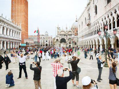 Turistas haciendo fotos en la plaza de San Marcos de Venecia.
