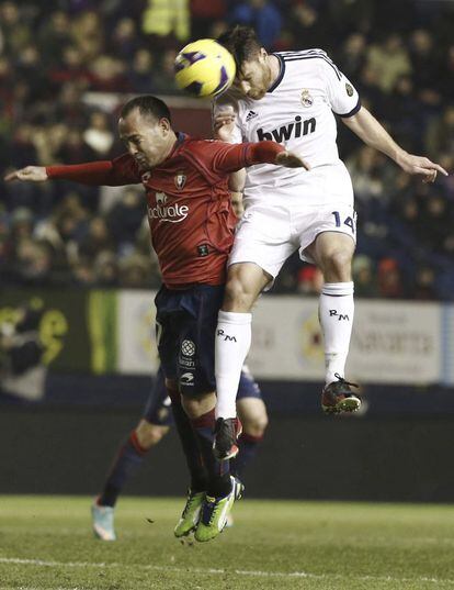 Xabi Alonso y el delantero del Osasuna Nino luchan por el balón.