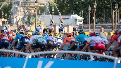 El pelotón del Tour, junto a un camión de la organización.