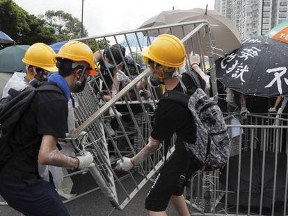 Manifestantes colocan vallas de metal para bloquear una vía en el distrito de Sha Tin, en Hong Kong. 