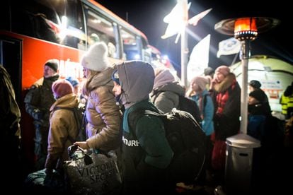 Un niño ucranio, en una fría noche en la frontera entre Polonia y Ucrania, espera un autobús que le lleve a la estación de tren de Przemyśl o al Centro Comercial Tesko, convertido en centro de primera acogida.