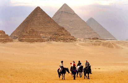 Turistas frente a las tres pirámides de Guiza.