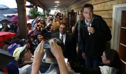 Mitt Romney se refugia de la lluvia durante un discurso en Mobile, Alabama.