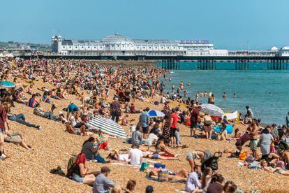 La gente disfruta del clima cálido en la playa de Brighton, Inglaterra, el 22 de junio de 2019.