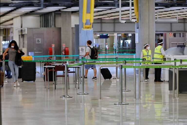 Pasajeros procedentes de Londres caminan entre los pasillos delimitados el 24 de junio de 2020.
