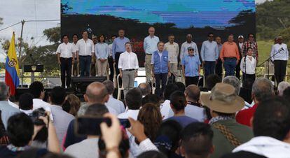 El presidente de Colombia Juan Manuel Santos (i), el representante de la ONU para el proceso de paz colombiano Jean Arnault (c) y Timochenko, el jefe de las Fuerzas Armadas Revolucionarias de Colombia (d) escuchan el himno nacional de Colombia durante un acto conmemorativo de la finalización del proceso de desarme de las FARC en Buenavista.
