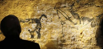 Una persona observa la pintura rupestre conocida como el hombre pájaro en la cueva de Lascaux (Francia).