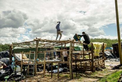 Los inmigrantes que esperan para cruzar el Canal construyen un refugio en la zona de Calais (Francia).