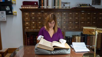 La investigadora Ane Galindo sostiene uno de los libros censurados de la Biblioteca Histórica de Santa Cruz, en Valladolid.