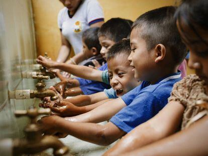Unos alumnos de la escuela rural de Los Vados (Guatemala) se lavan las manos antes de clase.