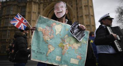 Un hombre con la careta del líder del eurófobo UKIP Nigel Farage protesta junto al Parlamento británico, este miércoles en Londres.