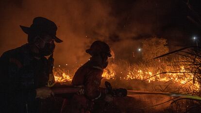 Bomberos trabajan en la extinción de un incendio en Indonesia.