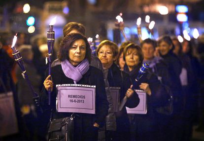 Un grupo de mujeres porta antorchas y esquelas en recuerdo de las víctimas de violencia de género.
