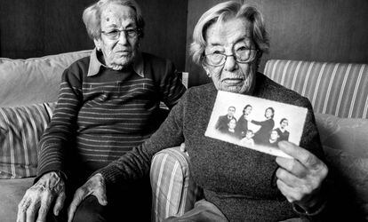 Las hermanas Lucía y Juana Molina Casado, que tienen 100 años, muestran un montaje fotográfico hecho para integrar en el retrato a los familiares ausentes.