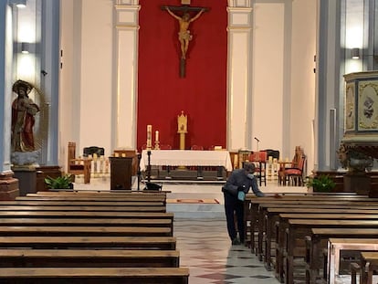 El párroco de Utiel, Agustín Alcayde, desinfecta los bancos de la iglesia.