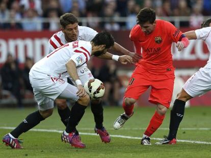 Messi prova de controlar la pilota, envoltada de jugadors del Sevilla.