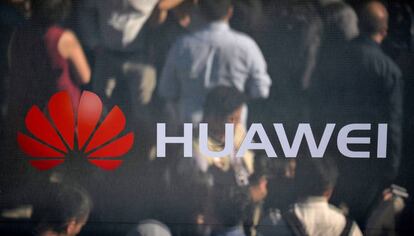 Varias personas se reflejan en un espejo con un logotipo de Huawei.