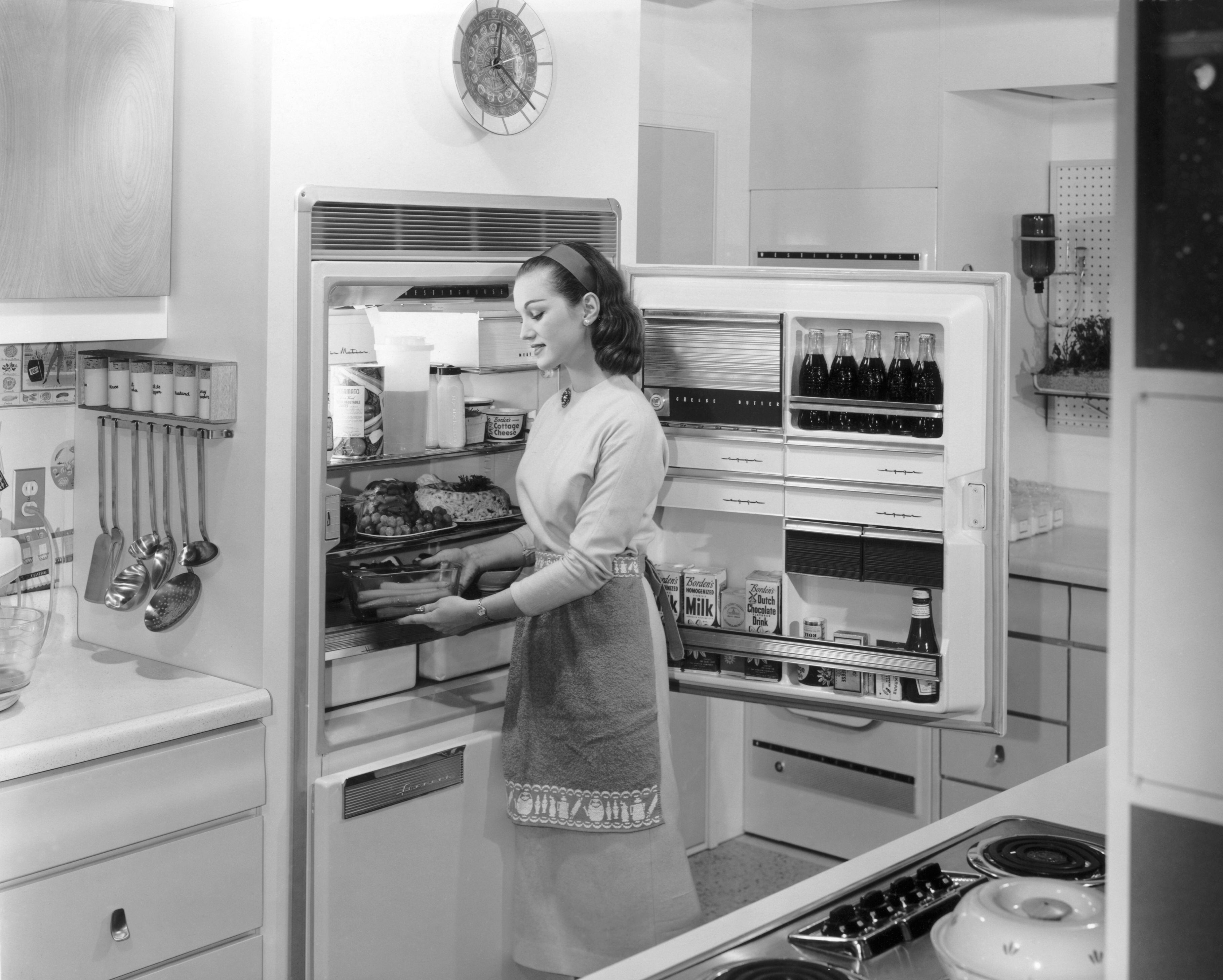 Una mujer coloca la compra en su frigorífico, en los años cincuenta.