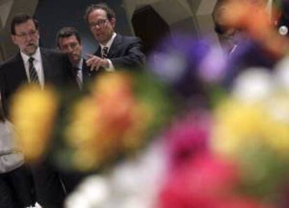 El presidente del Gobierno español, Mariano Rajoy, acompañado de José María Sicilia (d), durante la inauguración en el Museo de Bellas Artes de Fukushima de la exposición del artista español, titulada "Flores de Invierno", sobre las consecuencias del terremoto y el tsunami de 2011.