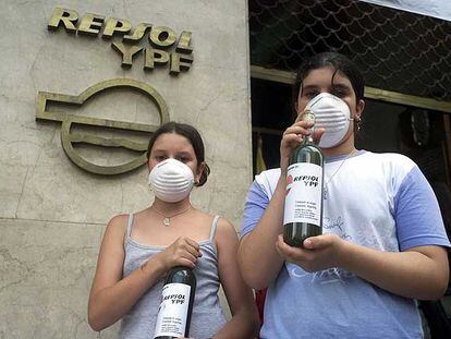 Activistas muestran botellas de agua contaminada en la sede de Repsol en Buenos Aires.