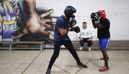 El educador Julio Rubio observa un entrenamiento de dos boxeadores en el centro vecinal de la UVA de Hortaleza. 