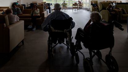 Residentes de un centro de mayores de la Comunidad de Madrid charlan y descansan en un salón del centro.