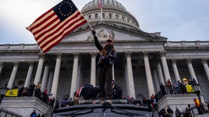 2FKA894 Washington DC, USA. 6th Jan, 2021. A man waves a flag in front of the Capitol Building during the storming of the building by Trump supporters.