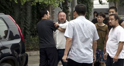 El artista chino Ai Weiwei se enfrenta a la policía a las puertas de su casa en Pekín.