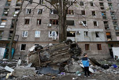 Un niño mira un coche destruido en la ciudad de Mariupol (sudeste). Rusia ha anunciado por primera vez un alto el fuego para abrir un corredor humanitario desde la acería de Azovstal sin pedir a cambio la rendición de los soldados ucranios, aunque las autoridades ucranias no han confirmado que se haya concretado.