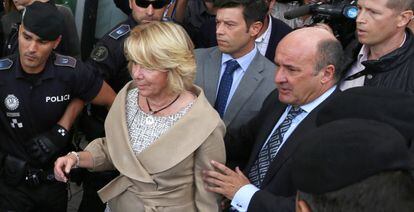 Gutiérrez Moliner, a la derecha, ayuda a Aguirre a entrar en el coche tras declarar ante el juez en septiembre por su incidente de tráfico.