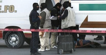 Médicos forenses levantan en Ciudad Juárez (México) los cadáveres de las cuatro personas que murieron esta madrugada cuando un grupo armado atacó tres autobuses.
