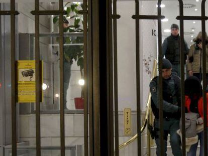 La Guardia Civil escolta a dos de los sospechosos de blanqueo durante el registro en la sucursal madrile&ntilde;a de ICBC. 
