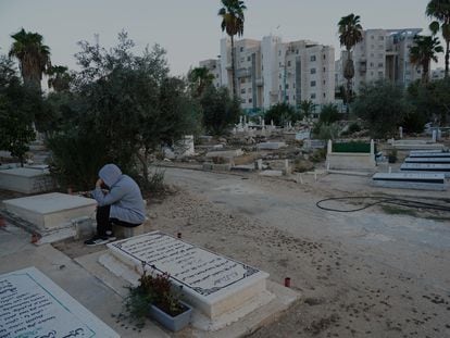 Cementerio musulmán en la ciudad de Lod (Israel) delante de los edificios en los que fueron realojados colonos judíos cuando fueron evacuados de la franja de Gaza en 2005, en una imagen del pasado jueves.