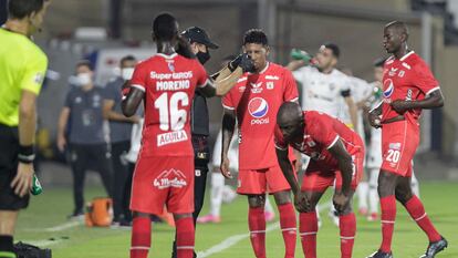 Un asistente ayuda a los jugadores del América de Cali afectados por los gases lacrimógenos durante su partido de Copa Libertadores contra Atlético Mineiro, en el estadio Romelio Martínez de Barranquilla.